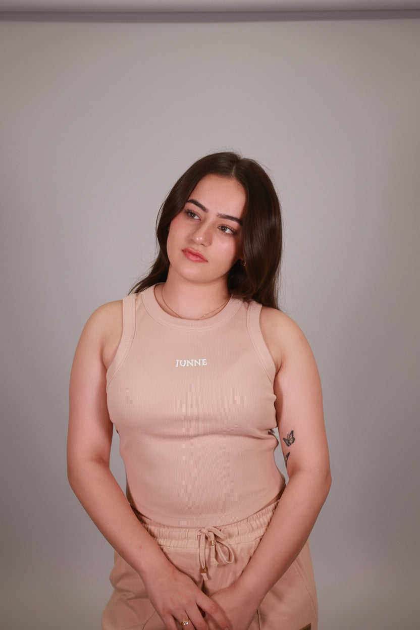 Woman wearing a beige dress with 'Chanel' branding against a neutral background